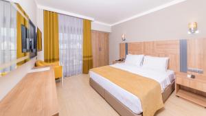 um quarto de hotel com uma cama e uma televisão em Julian Club Hotel em Marmaris