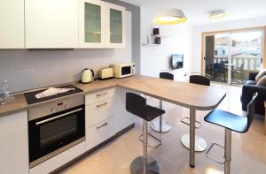 a kitchen with a counter and a table with chairs at La Perla: Sea View and Pool (family apartment) in El Médano