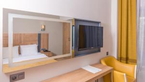um quarto com uma cama, uma secretária e uma televisão em Julian Club Hotel em Marmaris