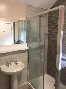 W łazience znajduje się umywalka i przeszklony prysznic. w obiekcie Cosy Apartment in Private Courtyard w mieście Preston