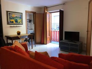 バゲリーアにあるBaarìa casa vacanzeのリビングルーム(赤いソファ、テレビ付)