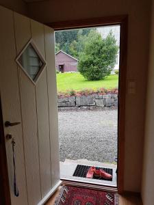 eine Tür zu einem Hof mit roten Schuhen draußen in der Unterkunft Ropeid Fjordferie in Ropeid