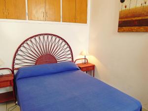 Schlafzimmer mit einem Bett mit blauer Tagesdecke in der Unterkunft Holiday Home Currican by Interhome in Empuriabrava