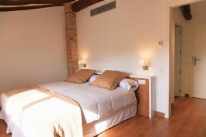 a bedroom with a large white bed with two pillows at Clos Figueras in Gratallops