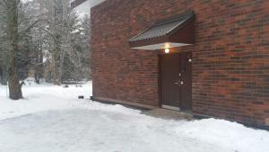ein Backsteingebäude mit einer Tür im Schnee in der Unterkunft Nice spacious home in Vaasa