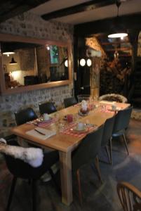 a large wooden table with chairs around it at La Cour Sainte Catherine demeure de charme in Honfleur