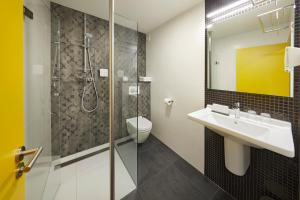La salle de bains est pourvue d'un lavabo et d'une douche. dans l'établissement Nova Hotel, à Amsterdam
