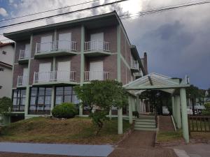 阿肖海Hotel Scoglie的一座大型砖砌建筑,旁边设有门廊