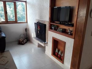 sala de estar con TV y chimenea en Casa de La Luna, en Monte Verde