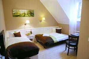 - une chambre avec deux lits, une table et une chaise dans l'établissement Waldhotel Wilhelmshöhe, à Freudenberg