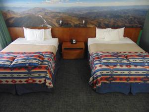 two beds in a room with a view of the mountains at Bryce Canyon Resort in Bryce Canyon