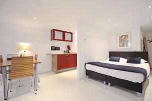 um quarto com uma cama, uma secretária e uma cozinha em Romantic Jordaan Canalsuite near Anne Frank House em Amsterdã