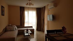 a living room with a couch and a window at Zefira Apartments in Pomorie