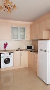 a kitchen with a white refrigerator and a dishwasher at Zefira Apartments in Pomorie