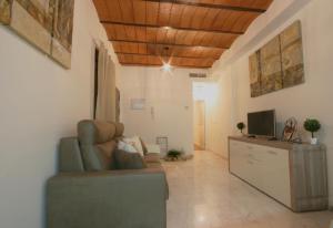 sala de estar con sofá y TV en Apartamento Vacacional Carmona, en Carmona