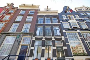 a tall building with many windows on a city street at Cozy Jordaan canalhouse near Anne Frank House in Amsterdam