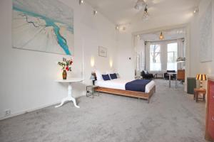 a bedroom with a bed and a table in a room at Cozy Jordaan canalhouse near Anne Frank House in Amsterdam