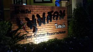 a brick wall with a sign with birds on it at Garden Corner Resort & Hotel in Phitsanulok