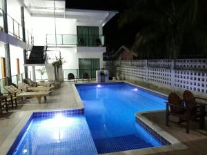 a swimming pool at night with chairs at Areia do Atlantico Hotel in Porto Seguro