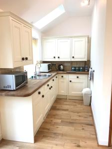 a kitchen with white cabinets and a sink at The Annex - Penzance town centre with parking in Penzance