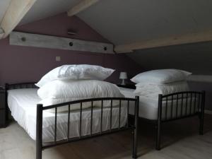 2 camas con sábanas blancas y almohadas en una habitación en La Bergerie de Ster, en Francorchamps