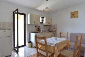 a kitchen with a table and a kitchen with a refrigerator at Apartmani Marko in Gdinj