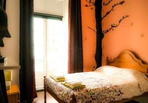 a bedroom with a bed with a tree mural on the wall at Azores Dream Hostel in Ponta Delgada