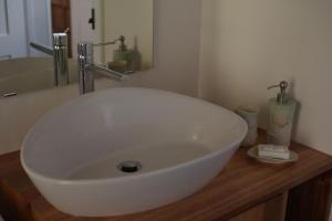 ein weißes Waschbecken auf einer Holztheke im Bad in der Unterkunft Canário do Mar - Rural Tourism in Angra do Heroísmo