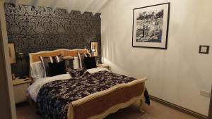 sypialnia z dużym łóżkiem i zdjęciem na ścianie w obiekcie Teardrop Cottage w mieście Knaresborough
