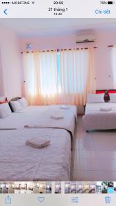 2 camas en una habitación con cortinas blancas en Quang Diep Motel, en Vung Tau