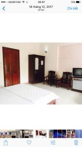 um quarto com uma cama e duas cadeiras e uma televisão em Quang Diep Motel em Vung Tau