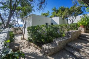 ein Haus am Strand mit einer Steinmauer in der Unterkunft Residenza La Cicala in Castro di Lecce