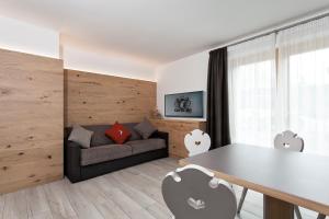 una sala de estar con un sofá y una mesa en Appartamento Fuoco, en Andalo