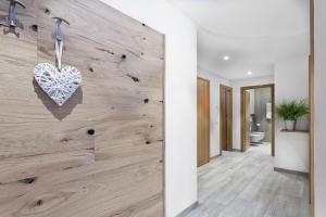 un pasillo con una pared de madera con un corazón. en Appartamento Fuoco, en Andalo 4 fotos más