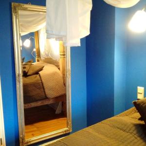 a mirror in a room with a bed and blue walls at Strumpfeck Suites in Traben-Trarbach