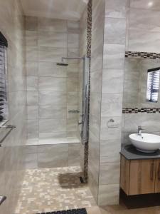 a bathroom with a shower and a sink at Cottage@Somerset in Somerset West