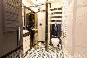 La salle de bains est pourvue de toilettes et d'un lavabo. dans l'établissement Apartamenty Parkowa, à Krynica-Zdrój