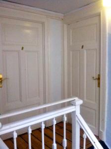 a white room with a staircase and two doors at St. Pauli Lodge Townhouse in Hamburg