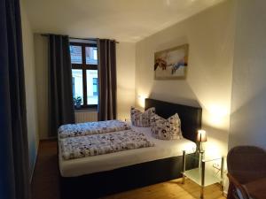 een slaapkamer met een bed met kussens en een raam bij Pension La rose in Brandenburg an der Havel