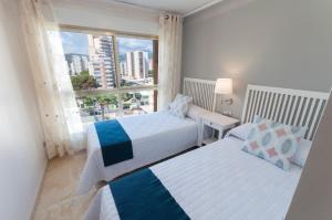 a bedroom with two beds and a large window at Ag Bermudas Deluxe in Gandía +149 photos