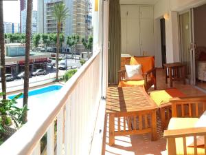 balcón con mesa, sillas y piscina en Apartment El Junco by Interhome, en Benidorm