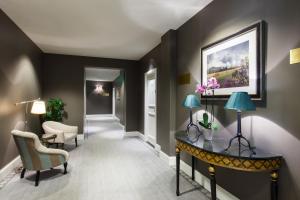 a room with a hallway with a table and chairs at Grand Palace Hotel - Small Luxury Hotels of the World in Riga