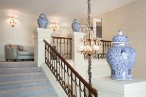 a staircase with a blue vase on a table at Grand Palace Hotel - Small Luxury Hotels of the World in Riga +21 photos