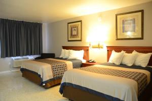 a hotel room with two beds and a window at The Lion Inn - Saint Augustine in Saint Augustine