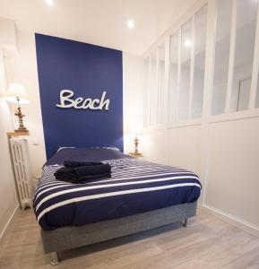 - une chambre dotée d'un lit avec un mur bleu dans l'établissement Studio "L'OCEANE", à Lorient