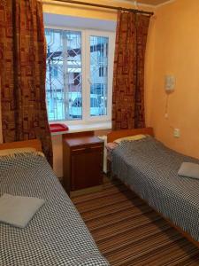 a room with two beds and a window at Hotel Europlus in Poltava