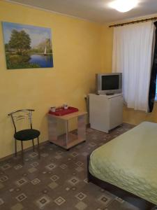 a bedroom with a bed and a tv and a desk at Hotel Europlus in Poltava