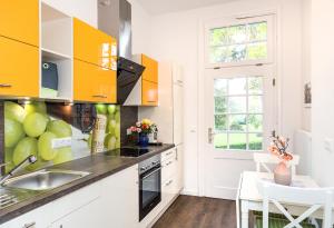 a kitchen with yellow cabinets and a sink at Komfortwohnung Innenstadt an der Schelfkirche in Schwerin