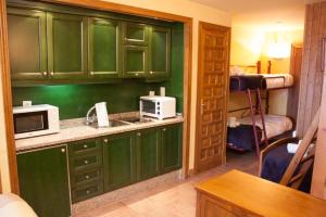 a kitchen with green cabinets and a microwave at IMEDA apartamento ATLAS Sierra Nevada in Sierra Nevada +4 photos