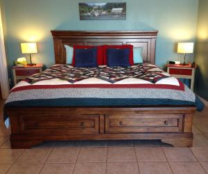 1 dormitorio con 1 cama con cabecero de madera en The Artisan Suites, en Hopewell Cape